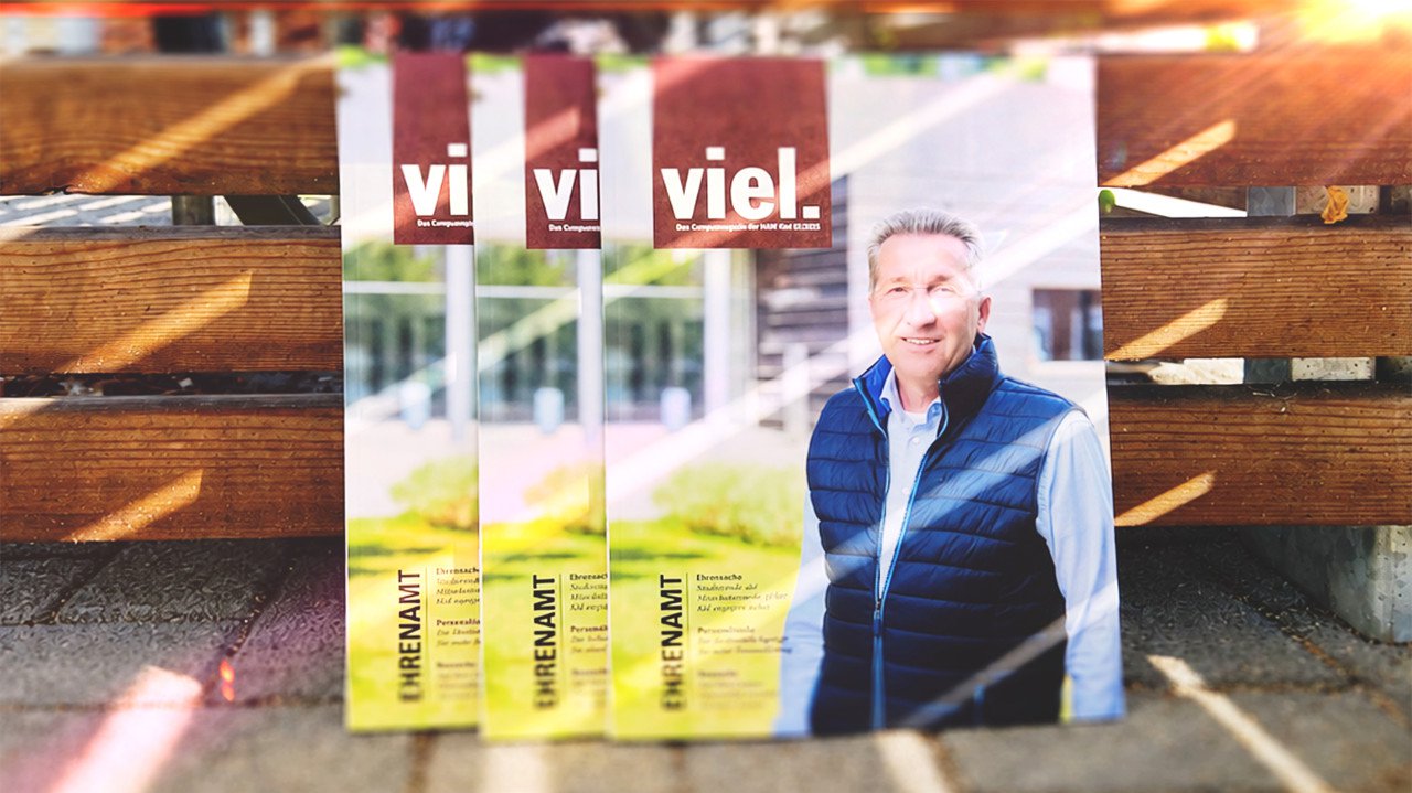 Drei Exemplare der viel. 33.-Ausgabe an eine Holzwand gelehnt
