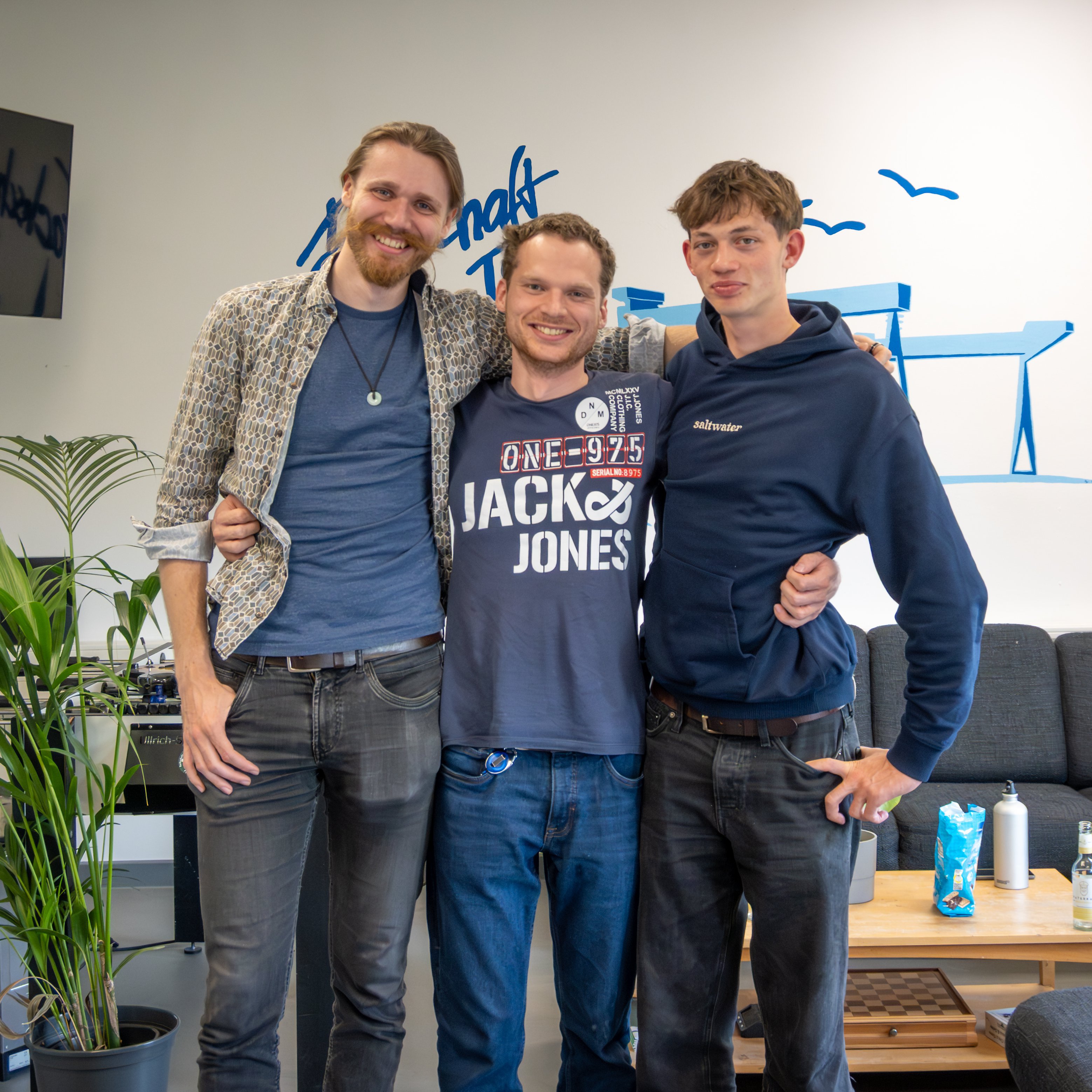 drei Männer stehen in einem Raum